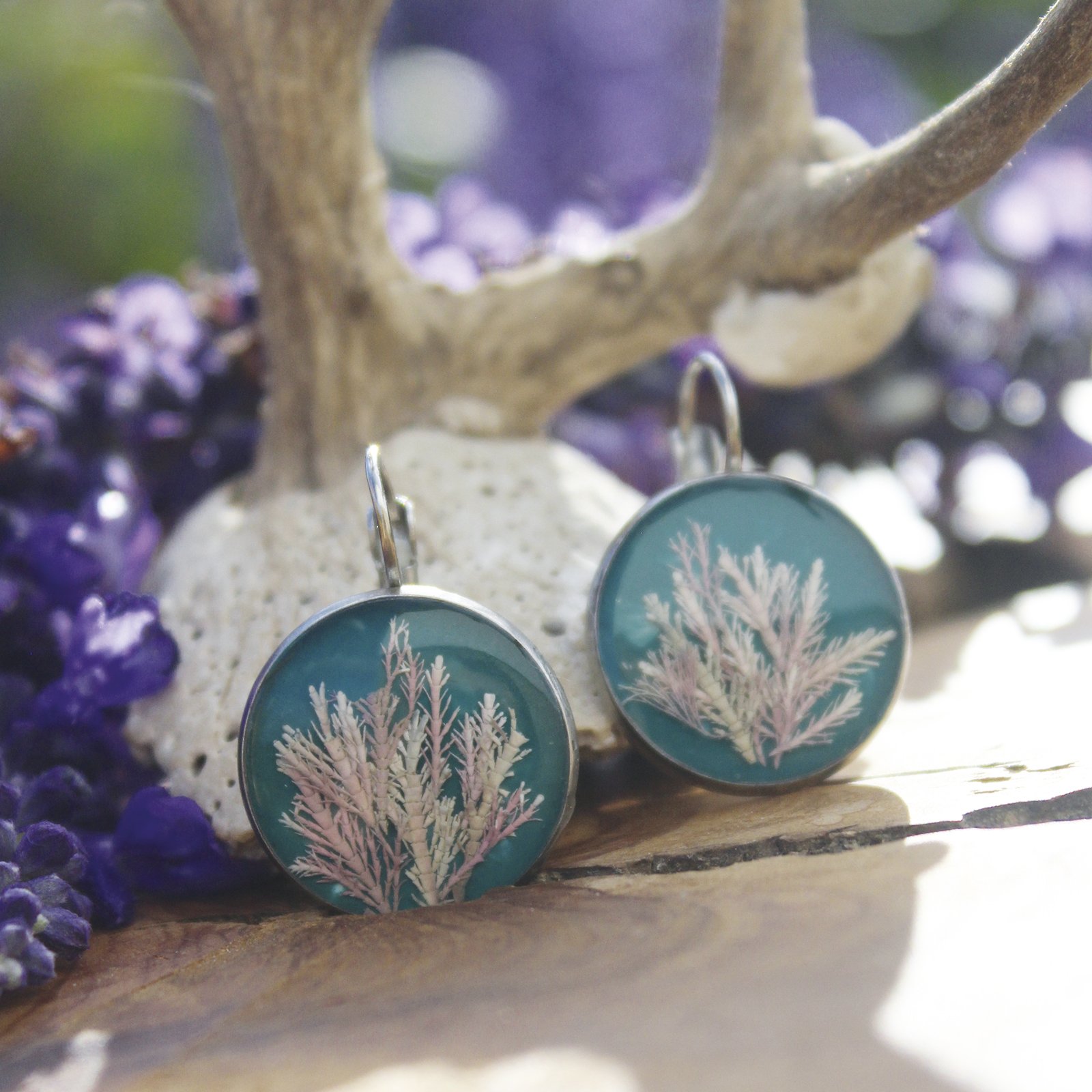 Pendientes de resina UV y acero hipoalergénico con alga coralina sobre fondo azul, hechos a mano en Malas Herbas Artesanía, artesanos gallegos.