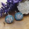 Pendientes de resina UV y acero hipoalergénico con alga coralina sobre fondo azul, hechos a mano en Malas Herbas Artesanía, artesanos gallegos.