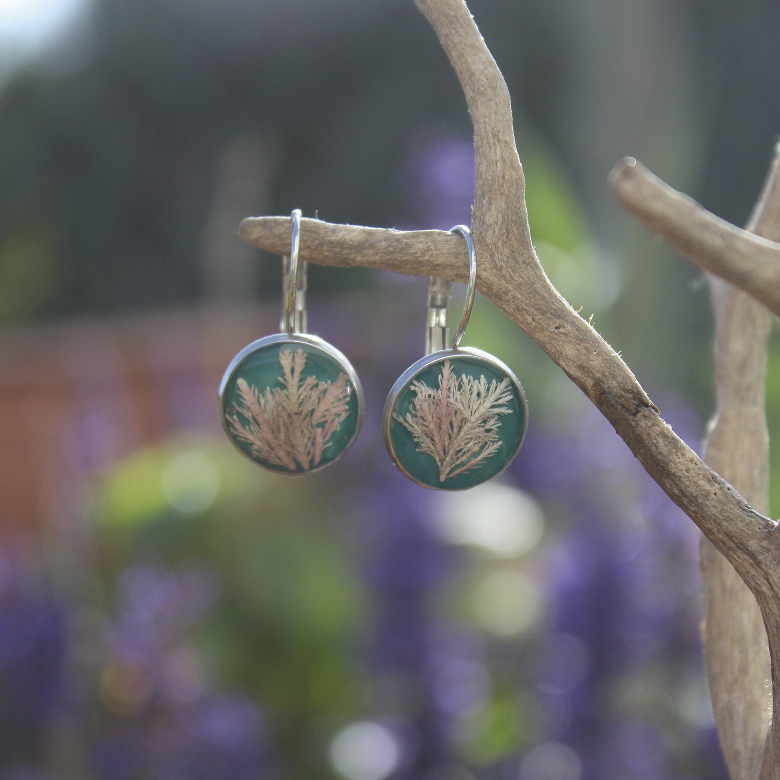 Pendientes de resina UV y acero hipoalergénico con alga coralina sobre fondo azul, hechos a mano en Malas Herbas Artesanía, artesanos gallegos.