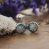 Pendientes de resina UV y acero hipoalergénico con alga coralina sobre fondo azul, hechos a mano en Malas Herbas Artesanía, artesanos gallegos.