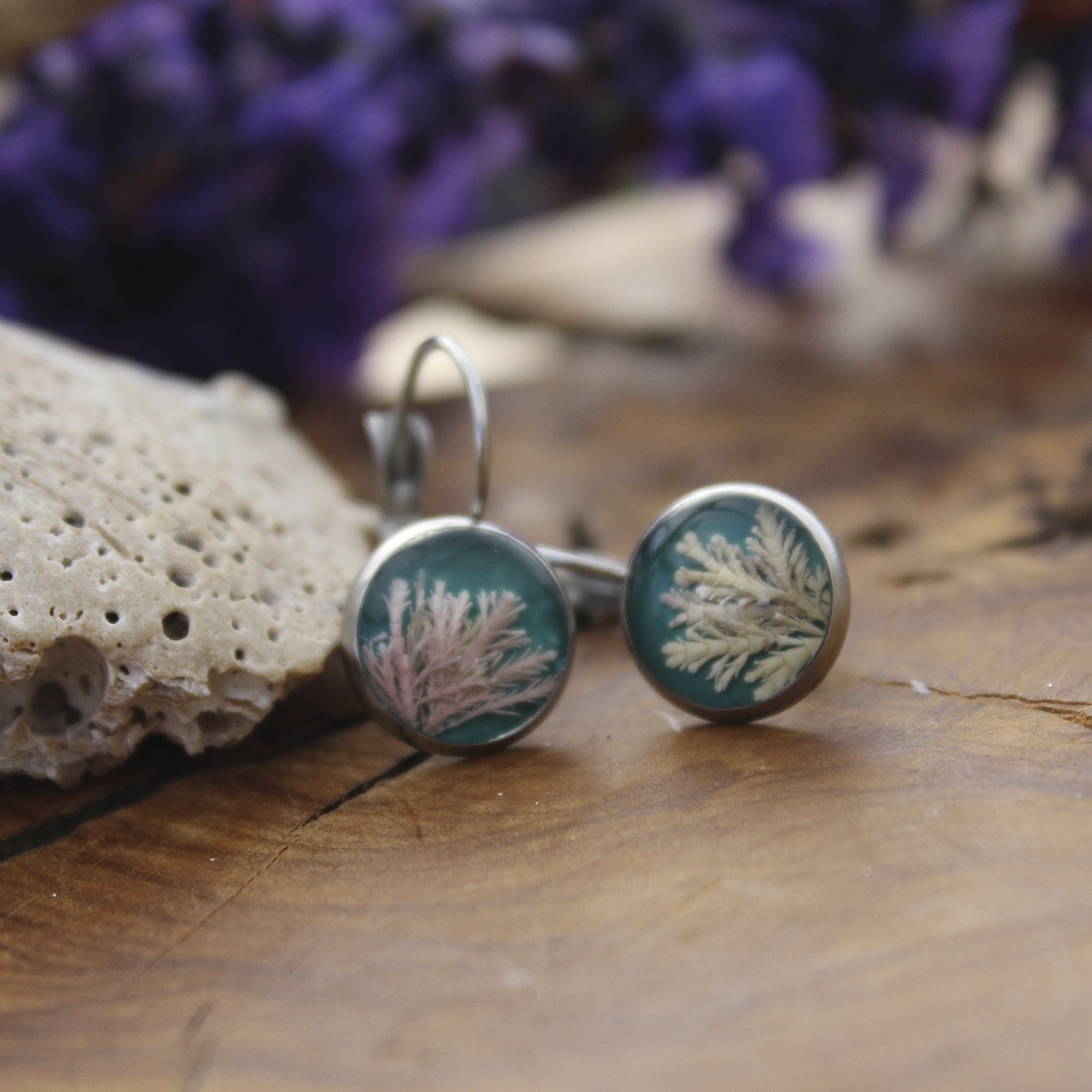 Pendientes de resina UV y acero hipoalergénico con alga coralina sobre fondo azul, hechos a mano en Malas Herbas Artesanía, artesanos gallegos.