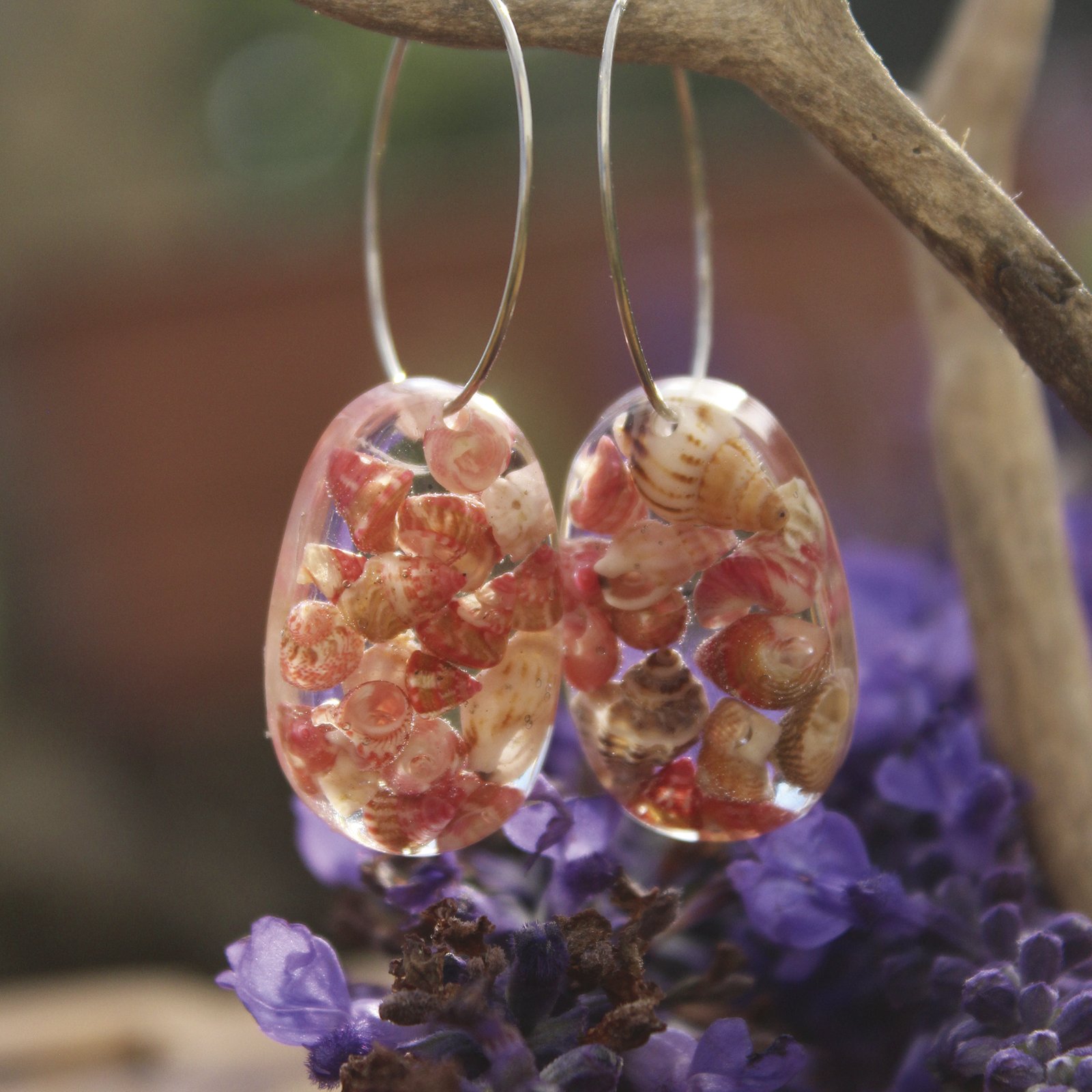 Pendientes de aro de acero hipoalergénico con conchitas marinas en resina UV, hechos a mano en Malas Herbas Artesanía, artesanos gallegos.