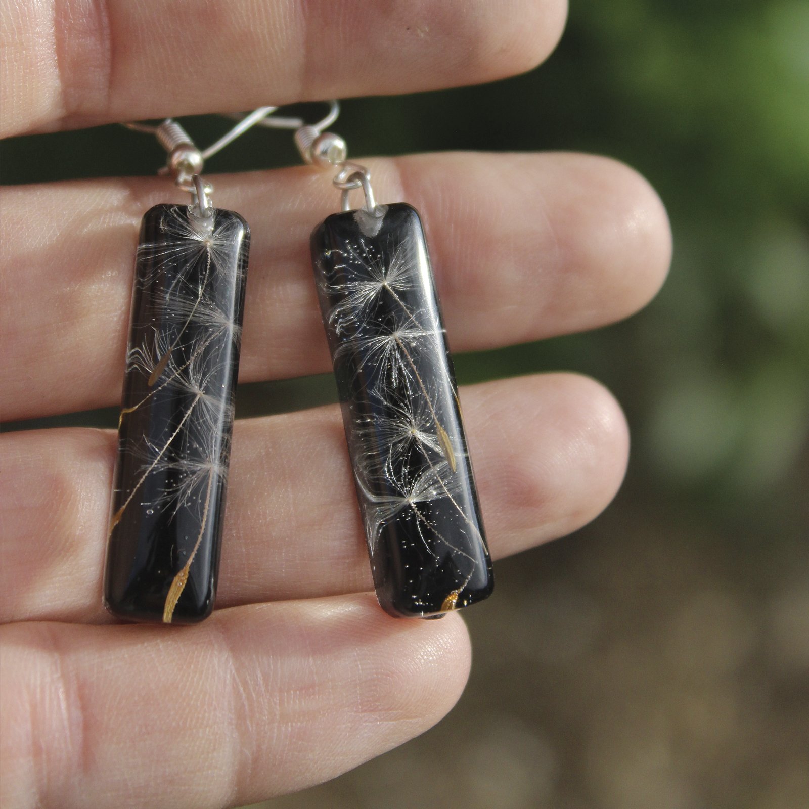 Pendientes alargados de resina UV y acero hipoalergénico con semillas de diente de león, hechos a mano en Malas Herbas Artesanía, artesanos gallegos.