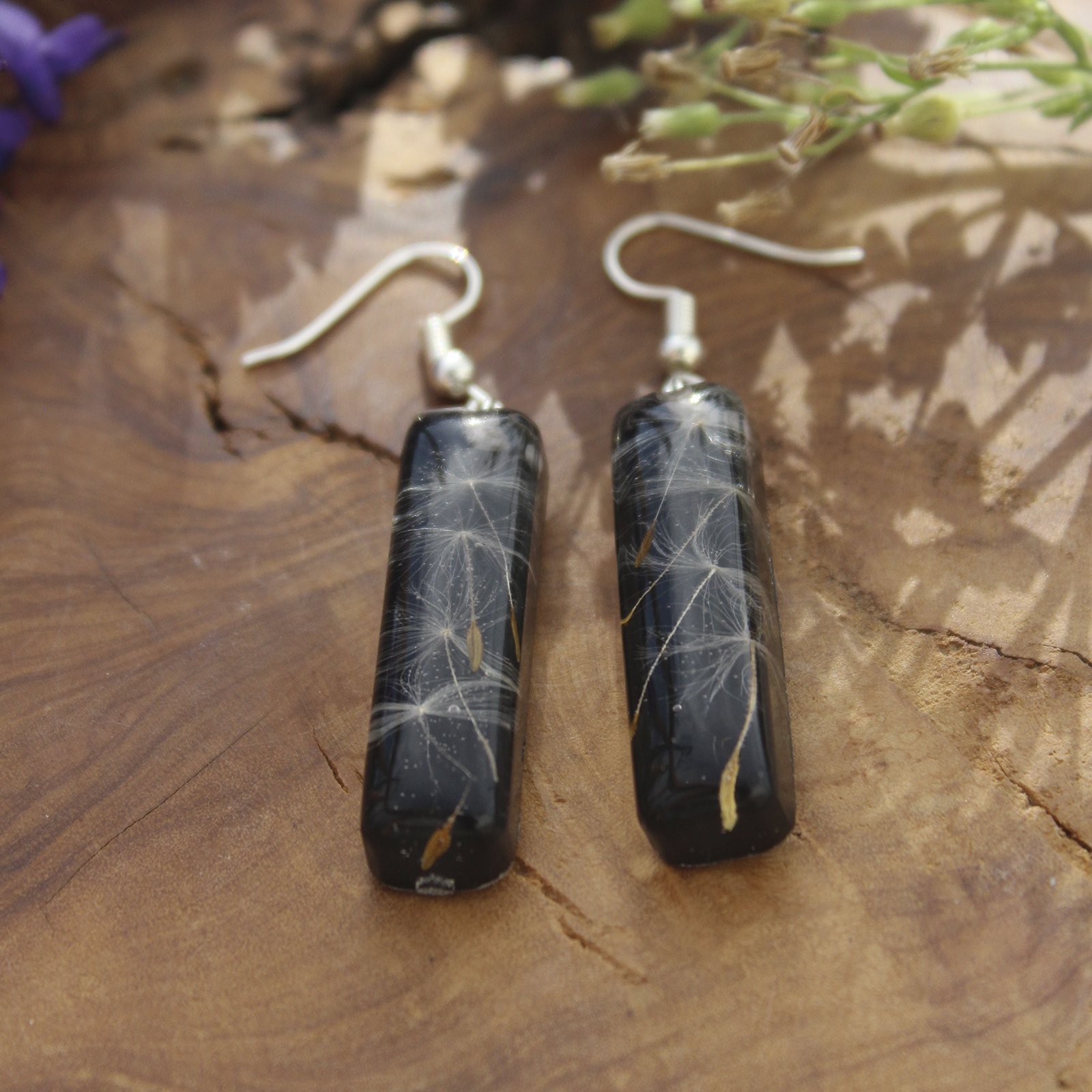 Pendientes alargados de resina UV y acero hipoalergénico con semillas de diente de león, hechos a mano en Malas Herbas Artesanía, artesanos gallegos.