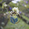 Pendientes de aro de acero dorado con hojitas de macramé en color azulón, hechos a mano en Malas Herbas Artesanía, artesanos gallegos.