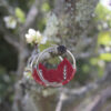 Pendientes de aro de acero plateado con hojitas de macramé en color rojo, hechos a mano en Malas Herbas Artesanía, artesanos gallegos.