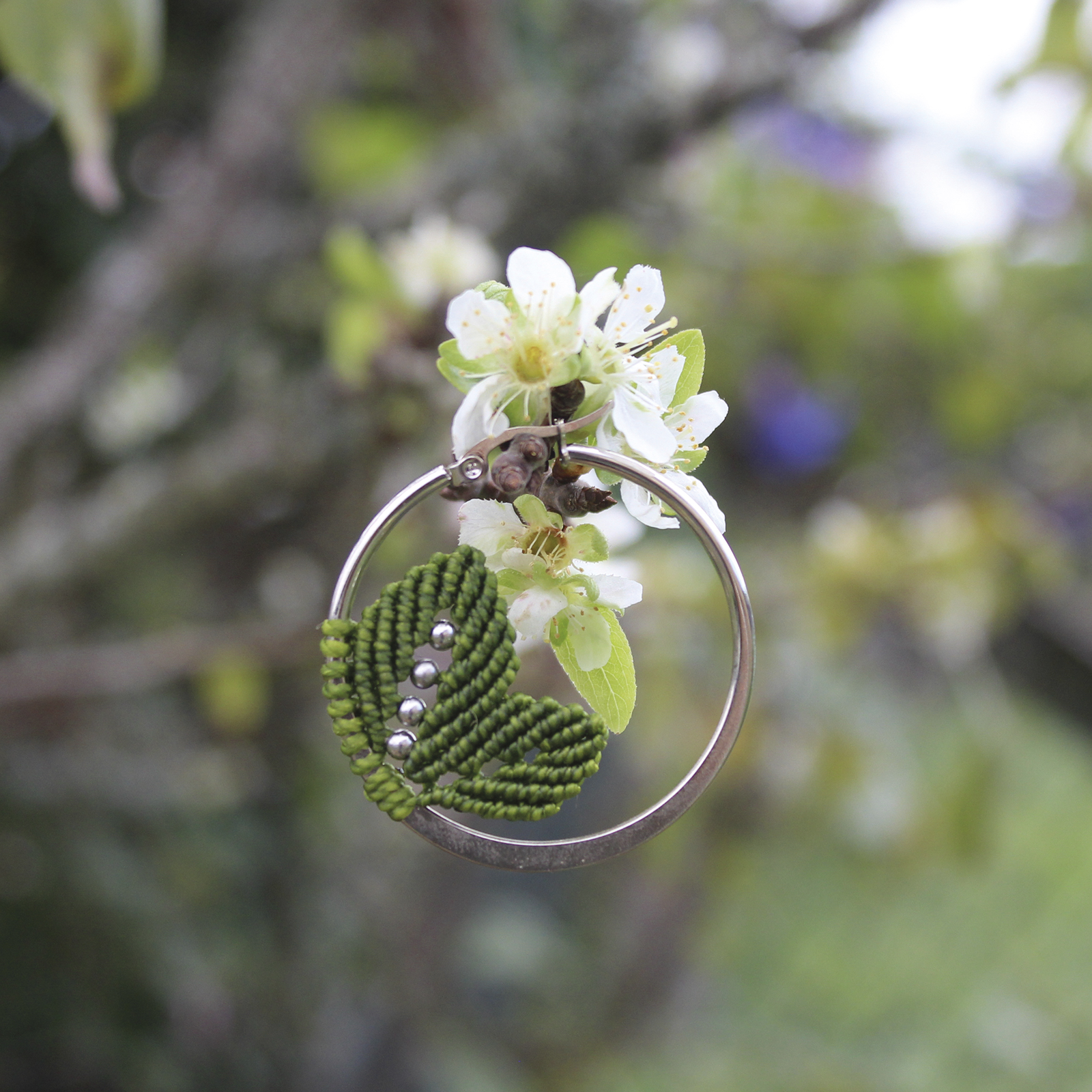 Pendientes de aro de acero plateado con hojitas de macramé en color verde, hechos a mano en Malas Herbas Artesanía, artesanos gallegos.